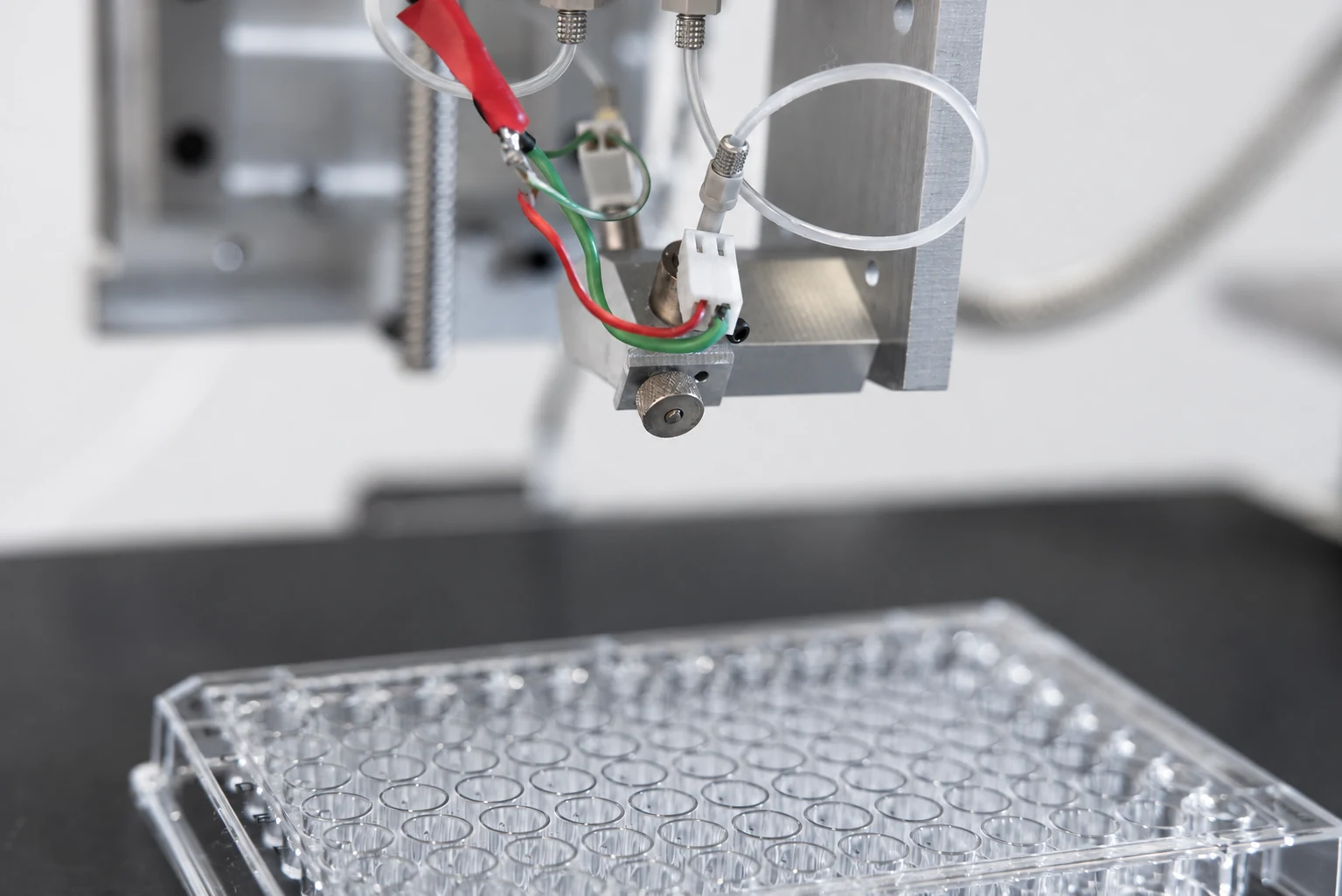 JetBio printhead and tubing above a multiwell plate.
